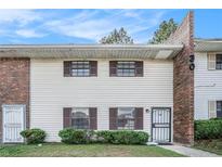 Charming two-story townhome features a brick accent and updated windows with dark shutters at 6354 Shannon Pkwy # 30C, Union City, GA 30291