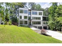 Stunning modern home with a well-manicured lawn and a combination of white siding and gray brick at 2110 Fairway Ne Cir, Brookhaven, GA 30319