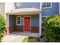 Charming townhouse entrance with a red door, brick accents, and covered porch, creating a welcoming curb appeal at 3263 Long Iron Pl, Lawrenceville, GA 30044