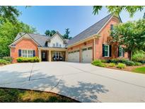 Beautiful brick home featuring an attached garage and well-maintained landscaping at 5220 Wild Cedar Dr, Buford, GA 30518