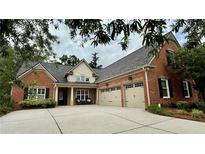 Charming two-story brick home featuring a two car garage and inviting front porch at 5220 Wild Cedar Dr, Buford, GA 30518