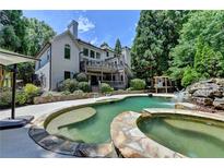 Inviting backyard pool and spa with waterfall feature and lush landscaping at 7920 Tintern Trce, Duluth, GA 30097