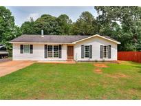 Charming single-story home with well-maintained lawn and inviting curb appeal and beautiful landscaping at 1050 Kirkland Rd, Covington, GA 30016