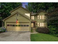 Charming two-story home featuring a two-car garage, lush landscaping, and a welcoming front entrance at 265 Lee River Cv, Suwanee, GA 30024
