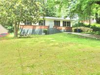 Charming home featuring a well-maintained front yard with mature trees, picnic table, and a classic exterior at 3086 Lone Oak Sw Ave, Atlanta, GA 30354