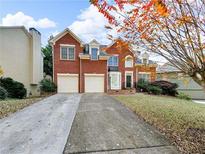 Two-story red brick home with a well-manicured lawn and a two-car garage at 3195 Vickery Dr, Marietta, GA 30066