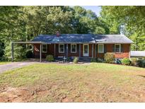 Charming brick home with a well-manicured lawn and covered parking at 4370 Tradition Ter, Austell, GA 30106