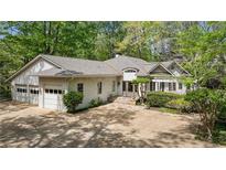 Charming single-story home with a lush green landscape, a two-car garage and a stone entryway at 5251 Powers Ferry Rd, Atlanta, GA 30327