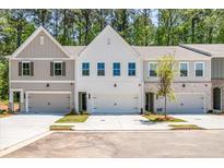 Charming townhome exterior featuring a manicured lawn, attached garage, and a welcoming facade at 1624 Ruskin Way, Marietta, GA 30062