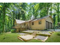 Charming home with a deck, two-car garage, and a well-maintained yard surrounded by lush greenery at 5837 Fox Run, Rex, GA 30273