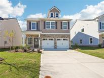 Charming two-story home featuring a brick facade, two-car garage, and well-manicured lawn at 11854 Rizvan Pl, Covington, GA 30014