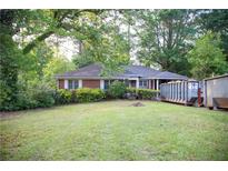 Charming brick home with a well-manicured front lawn and mature trees at 1398 Christmas Ne Ln, Atlanta, GA 30329