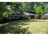 Charming brick home featuring a well-manicured front yard with mature trees at 1398 Christmas Ne Ln, Atlanta, GA 30329