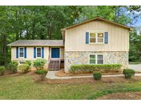 Charming two-story home with stone accents, blue shutters, landscaped yard, and inviting front entrance at 1415 Hialeah Ct, Marietta, GA 30062