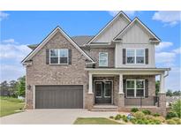 Beautiful two-story brick home with a covered porch, two-car garage and manicured landscaping at 3139 Hilltop Drive, Marietta, GA 30066