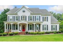 Elegant two-story white home with black shutters, inviting front porch, and well-manicured lawn at 6219 Creekstone Path, Cumming, GA 30041