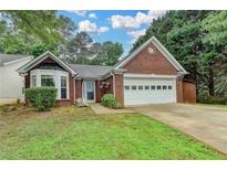 Charming one story brick home with manicured lawn and attached two car garage at 1965 Sterling Creek Ct, Snellville, GA 30078