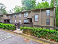 A well-maintained condo complex showcasing lush greenery and multiple windows for ample natural light at 2210 Cumberland Se Ct, Smyrna, GA 30080