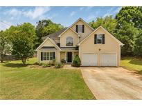 Charming two-story home with a well-maintained lawn, two car garage and mature landscaping at 4001 English Valley Dr, Ellenwood, GA 30294