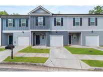 Charming townhomes with attached garages, well-kept lawns, and coordinated neutral color schemes at 5095 Lower Elm St, Atlanta, GA 30349