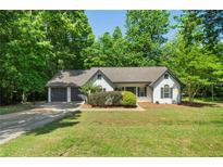 Charming ranch home with a two-car garage, set on a lush lot with mature trees and manicured landscaping at 545 Willow Creek Dr, Temple, GA 30179