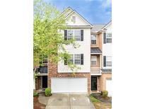Charming three-story townhouse with a two-car garage and beautifully maintained landscaping at 1646 Sandy Beach Pt, Lawrenceville, GA 30043