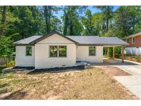 Charming renovated single-story home with a neutral painted brick, covered carport, and well manicured landscaping at 2133 Trailwood Rd, Decatur, GA 30032