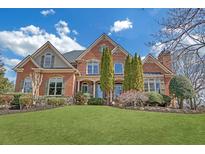 Stately brick home featuring a lush lawn, manicured landscaping, and architectural details at 2740 Heritage Bend Sw Ct, Grayson, GA 30017