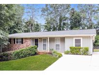 Charming single-story home with a well-maintained lawn and classic brick accents at 4820 Oak Grove Dr, Cumming, GA 30040