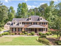 Stately brick home with a manicured lawn and charming front porch, surrounded by mature trees at 3510 Eagle Landing Dr, Snellville, GA 30039