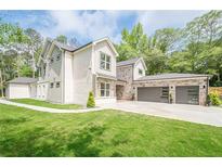 Beautiful home featuring a well-manicured lawn, a three car garage, stone accents and a grey and white color scheme at 1273 Grayson Pkwy, Grayson, GA 30017