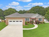 Charming brick home with a well-manicured lawn, two-car garage, and inviting walkway at 1419 Gates Mill Walk, Lawrenceville, GA 30045