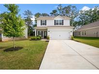Charming two-story home with a well-manicured lawn and a concrete driveway leading to an attached two-car garage at 217 Limestone Cir, Conyers, GA 30013