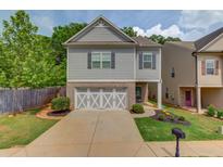 Charming two-story home with a well-manicured lawn and a welcoming front entrance and a two car garage at 2275 Black Pebble Cir, Buford, GA 30519