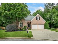 Charming brick home featuring a well-manicured lawn, two-car garage, and mature trees at 1444 Merrifield Ln, Marietta, GA 30062