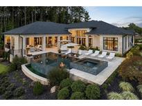 A beautiful backyard featuring a pool, hot tub, fire pit, and lounge area, perfect for outdoor entertaining at 3085 Lake Park Dr, Jonesboro, GA 30236