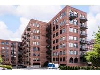 Brick apartment building with windows, balconies, and arched windows on a partly cloudy day at 3235 Roswell Ne Rd # 514, Atlanta, GA 30305