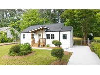 Charming renovated home with new landscaping, gray roof, white siding, and an inviting front porch at 1111 Edgefield Sw Dr, Atlanta, GA 30310