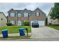 Two-story brick home with a well-maintained lawn and two-car garage at 4925 Locherby Dr, Fairburn, GA 30213