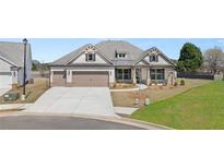 Charming single-story home with a three-car garage, manicured lawn, and a blend of brick and siding at 1609 Tielman Way, Snellville, GA 30078