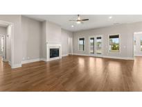 Open living room featuring hardwood floors, fireplace, ceiling fan and backyard access at 1609 Tielman Way, Snellville, GA 30078