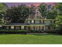 Charming two-story brick home with a well-manicured lawn and mature trees offering great curb appeal at 3824 N Cooper Lake Se Rd, Smyrna, GA 30082