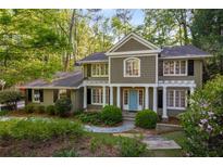 Charming two-story home featuring a landscaped front yard and a welcoming blue front door at 6990 Brandon Mill Nw Rd, Atlanta, GA 30328