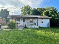 Cozy one-story home with white painted brick, covered porch, and lawn at 1471 Holcomb Ave, Atlanta, GA 30344