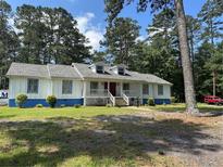 Charming single story home with a white facade, blue trim, dormer windows, and a welcoming front porch at 1833 Stephenson Rd, Lithonia, GA 30058