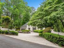 Stunning exterior view of a luxurious home with a circular driveway and lush landscaping at 550 Atlanta Country Club Se Dr, Marietta, GA 30067