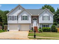 Charming two-story home with a two-car garage, stone accents, and a well-maintained lawn at 607 Lexington Way, Woodstock, GA 30189