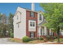 Charming home featuring brick and neutral siding, a front porch, and well-maintained landscaping at 106 Weatherstone Square Drive, Woodstock, GA 30188