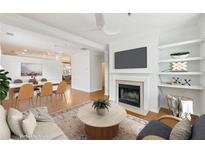 Bright open-concept living room with fireplace, built-in shelving, and an adjacent dining area at 106 Weatherstone Square Drive, Woodstock, GA 30188