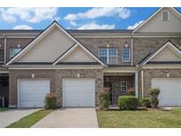 Charming brick townhome featuring a one-car garage and well-maintained landscaping, inviting curb appeal at 2555 Flat Shoals Rd # 1405, Atlanta, GA 30349